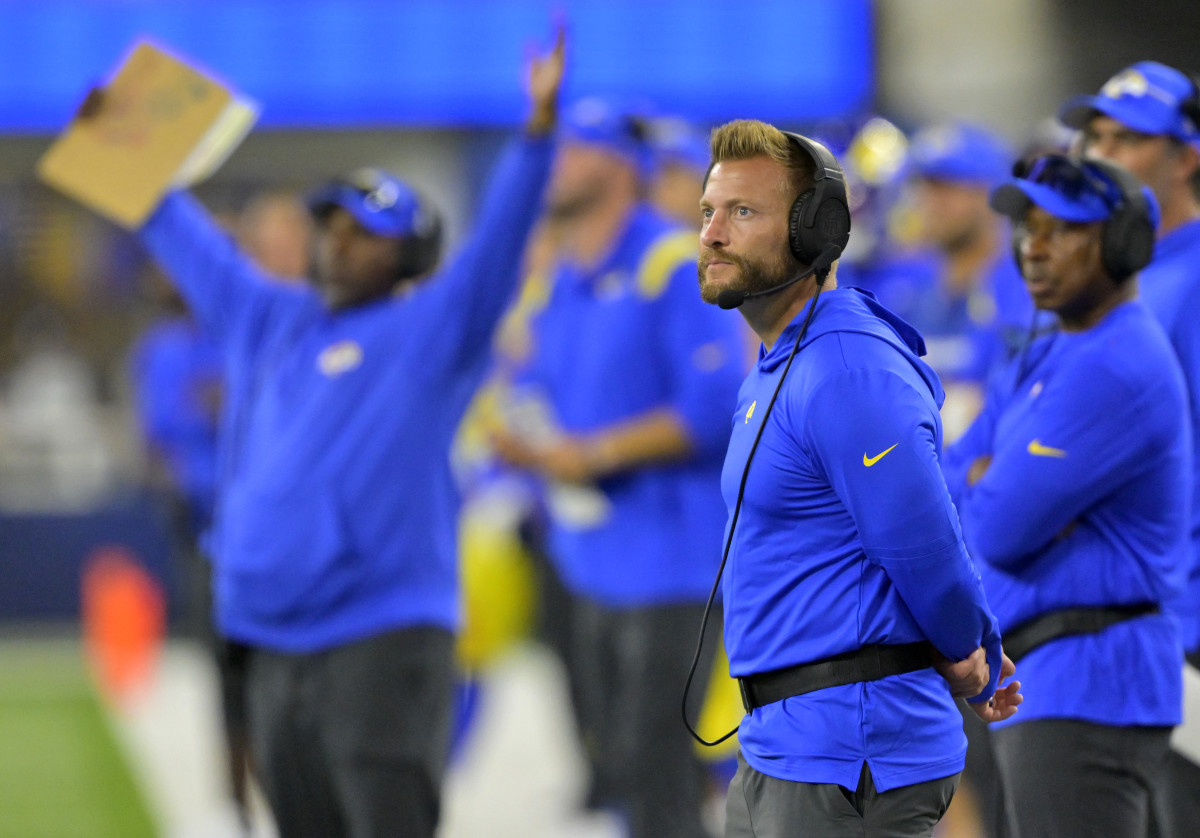 Sean McVay stands on the sideline looking out at the field